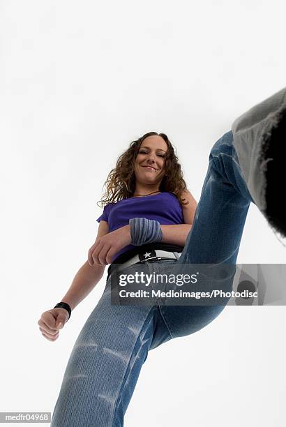 low angle view of a young woman standing with legs apart - female body piercing fotografías e imágenes de stock