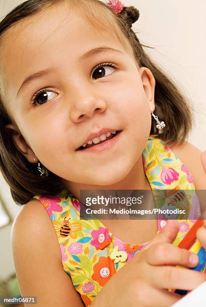 three year old girl in flowered clothing holding markers, close-up - year on year stock pictures, royalty-free photos & images