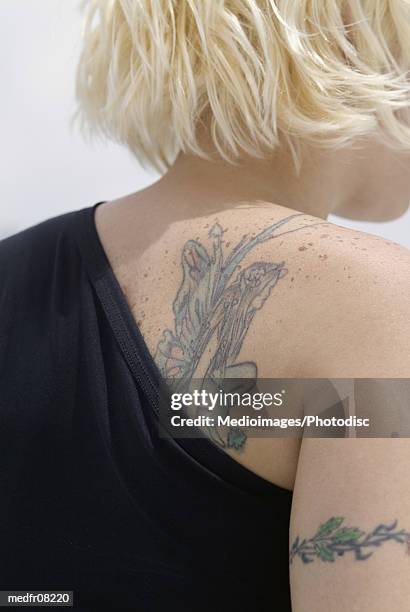 rear view of a young woman's tattooed back - bizarre fashion stock pictures, royalty-free photos & images