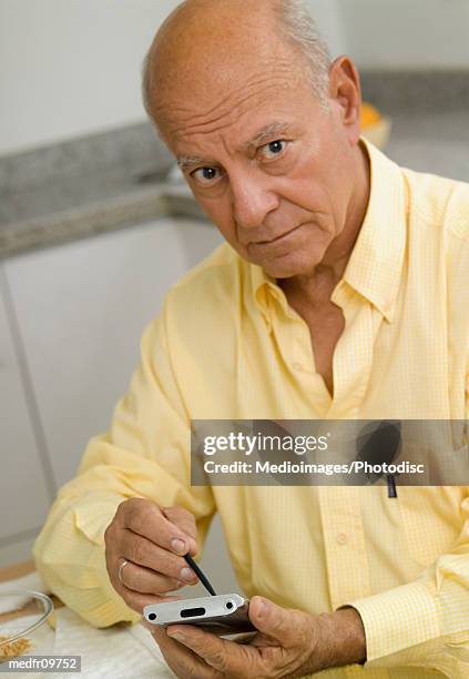 elderly man using digital hand held device - silver surfer stock pictures, royalty-free photos & images