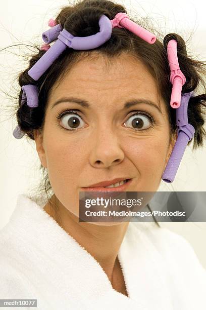 woman with hair curlers making face at camera - hair curlers stockfoto's en -beelden