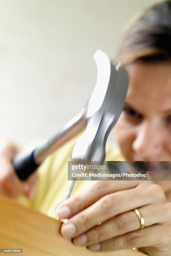 Woman using hammer, close-up, selective focus, focus on hand and nail