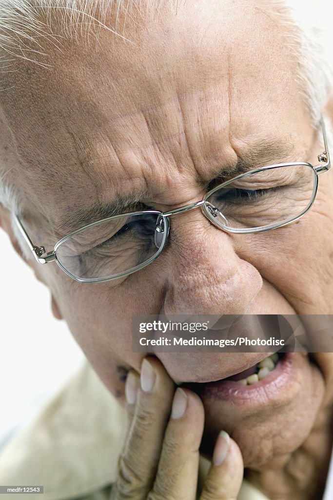 Portrait of senior man with toothache, close-up