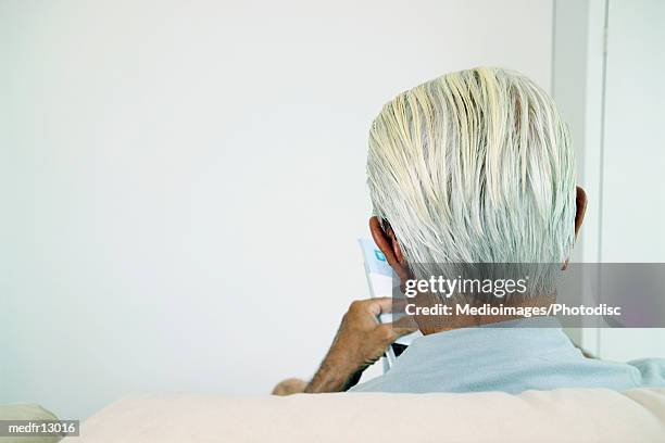 rear view of senior man sitting and reading, close-up - man rear view grey hair closeup stock pictures, royalty-free photos & images