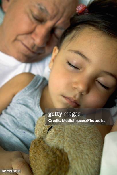 three year old sleeping with grandfather and stuffed dog, close-up - year on year stock pictures, royalty-free photos & images