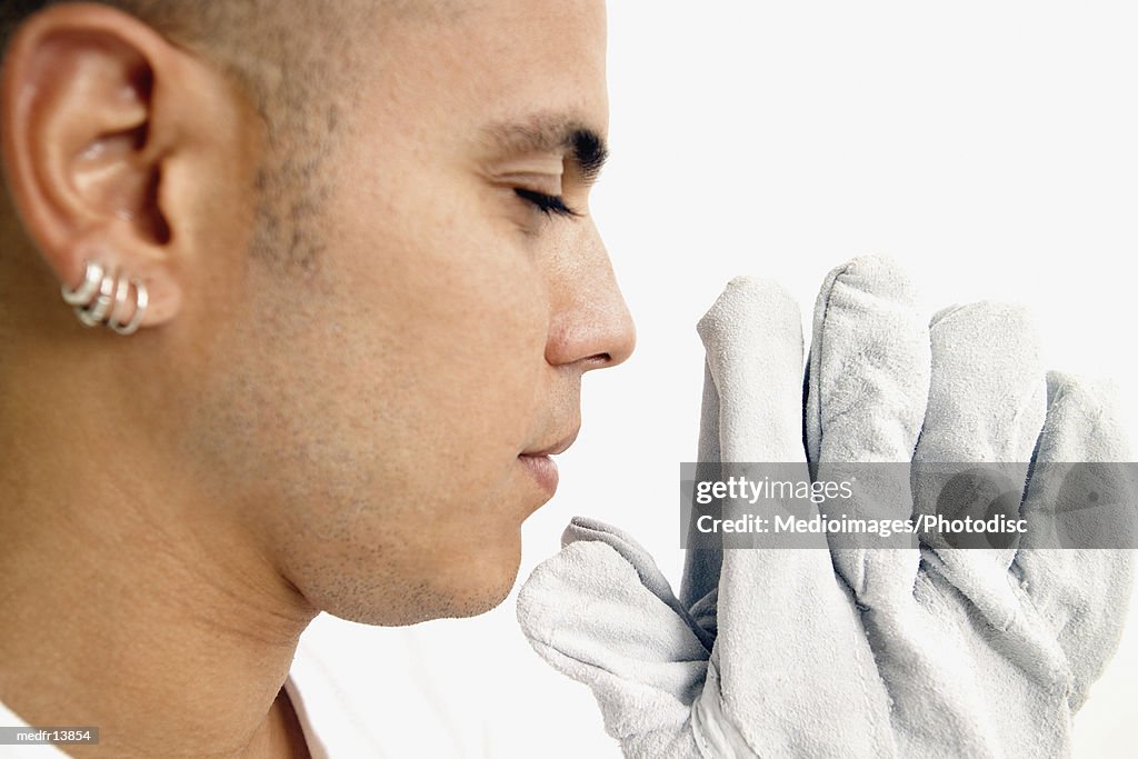 Young man with leather gloves praying, close-up