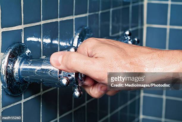 hand turning water faucet in shower, close-up - shower tap stock pictures, royalty-free photos & images