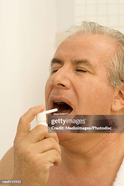 elderly man using a mouth spray - mouth spray stock pictures, royalty-free photos & images