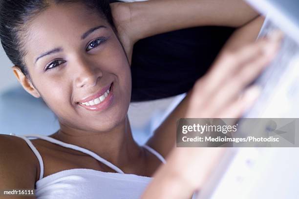 smiling teenage girl lying down with laptop at home, close-up, lens flare - portrait lens flare stock pictures, royalty-free photos & images