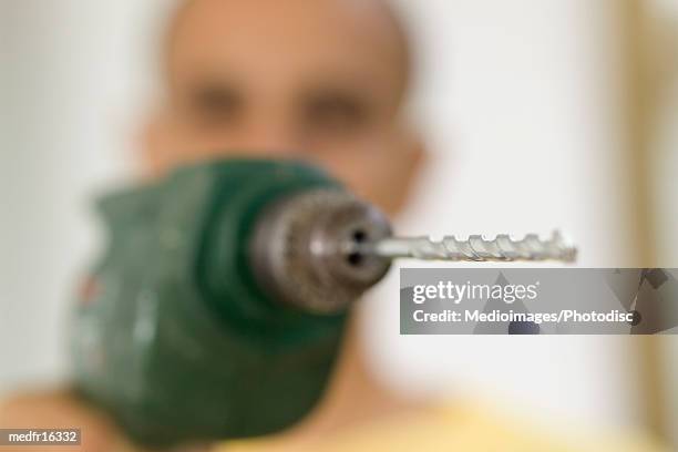 close-up of the tip of a drill bit of an electric drill held by a man - bit stock-fotos und bilder