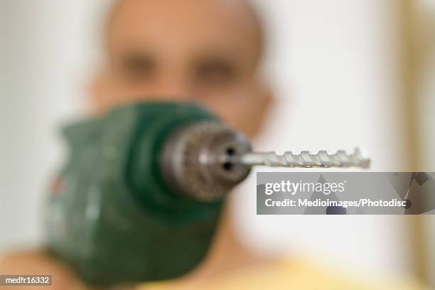 close-up of the tip of a drill bit of an electric drill held by a man - drill bit stockfoto's en -beelden