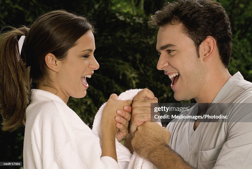 Smiling young couple outdoors with towel, close-up