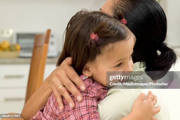 senior woman hugging three year old girl in kitchen, close-up, selective focus - federation of new yorks music visionary of the year award luncheon stockfoto's en -beelden