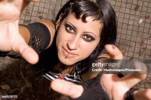 smiling young goth woman with hands raised, close-up - body modification stock-fotos und bilder