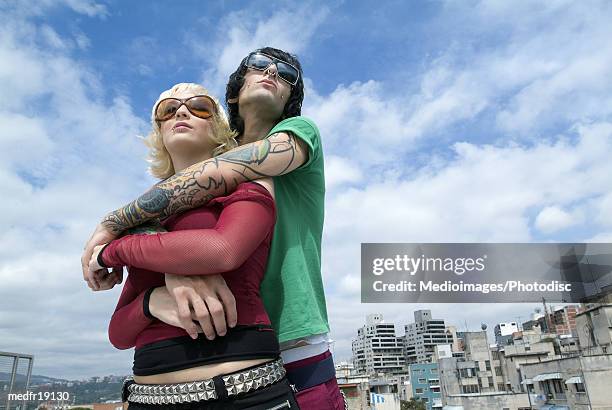 low angle view of a young couple standing together looking ahead - ahead stock pictures, royalty-free photos & images