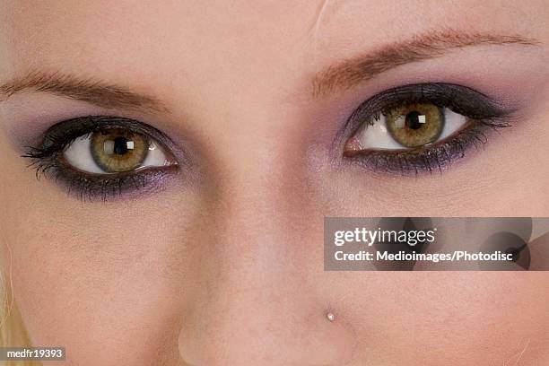 extreme close-up of young woman's eyes and nose - body modification stock-fotos und bilder