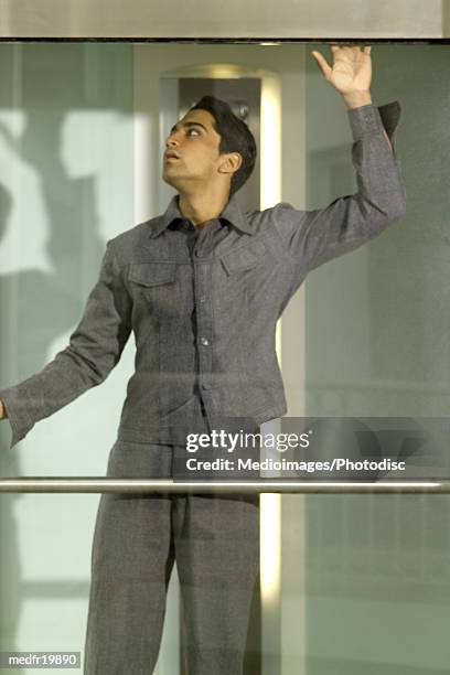 man leaning on the glass wall of an elevator - elevator trapped stock pictures, royalty-free photos & images