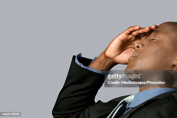 businessman leaning back with hand on forehead, close-up - hand on head foto e immagini stock
