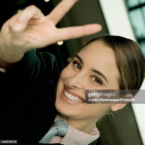 smiling young businesswoman making v sign with fingers, close-up, tilt - v neck fotografías e imágenes de stock