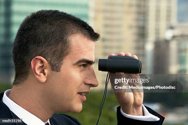 businessman looking through binoculars outdoors, close-up - staring contest stock pictures, royalty-free photos & images