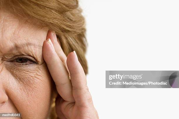 senior woman with headache and hand on forehead, extreme close-up - hazel eyes stock pictures, royalty-free photos & images