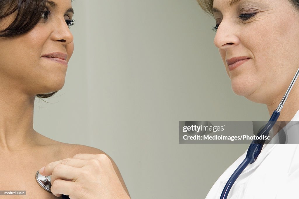 Female doctor listening to woman's chest