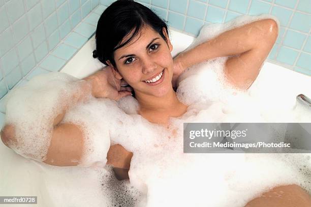 high angle view of a young woman in a bubble bath - beautiful woman bath stock-fotos und bilder