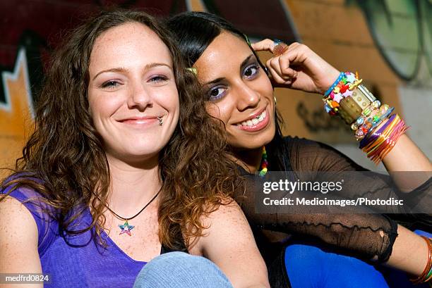 portrait of two young women with piercing on the face - hand on head ストックフォトと画像