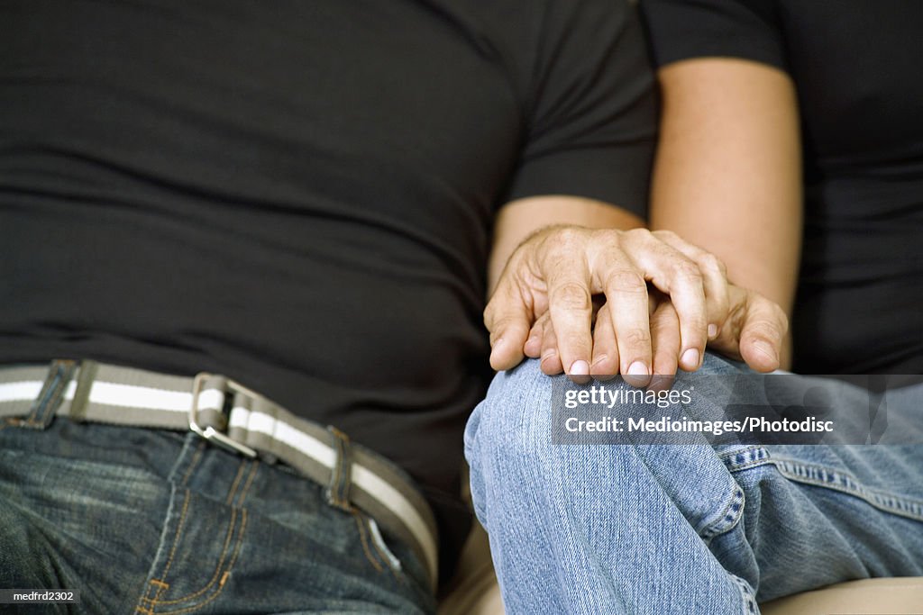 Close-up of two men holding hands