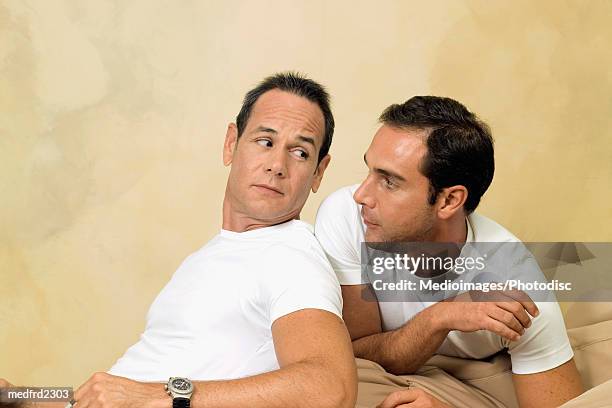 portrait of two men lying on a soft couch - couple portrait soft ストックフォトと画像