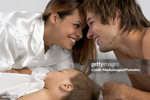 happy mother and father in bed while baby is sleeping, close-up - happy stockfoto's en -beelden