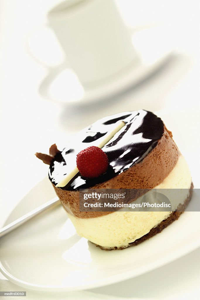 Small ice cream cake with coffee cup in background, close-up, tilt, selective focus