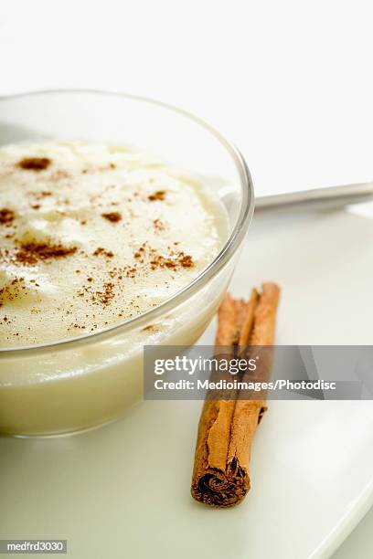 bowl of rice pudding and cinnamon stick, close-up, part of - milchreis stock-fotos und bilder