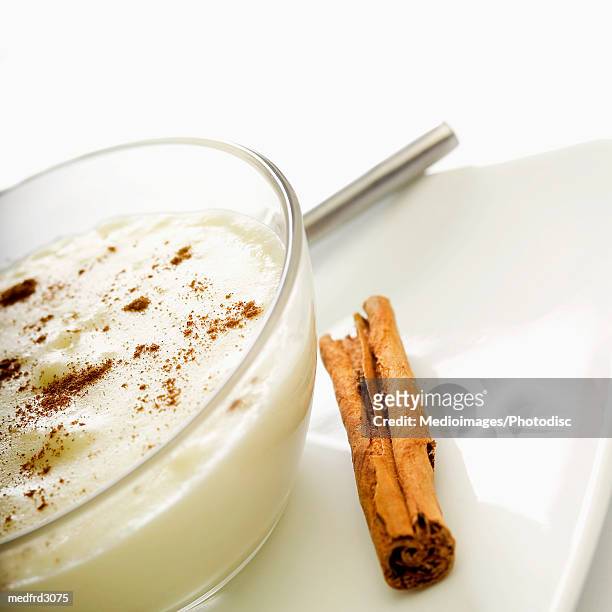 bowl of rice pudding and cinnamon stick, close-up, part of - stick plant part stockfoto's en -beelden