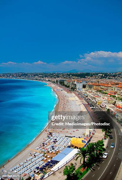 tourists and umbrellas on beach promenade des anglais in nice, provence cote d'azur, on the fren - cote d’azur stock pictures, royalty-free photos & images