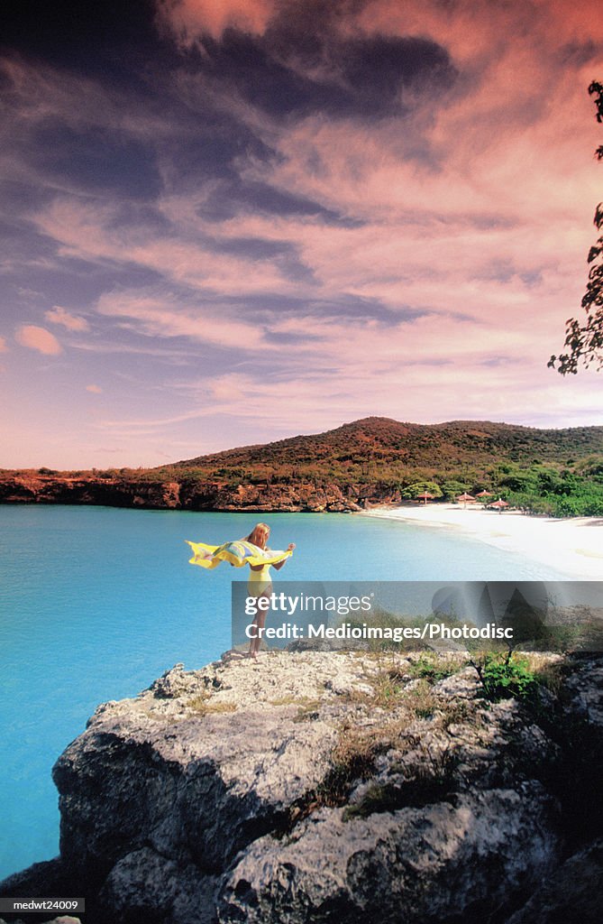 Woman wearing a pareu and standing on the cliffs of Knip Beach, Curacao, Caribbean