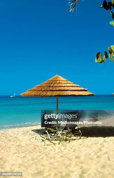 straw umbrella and lounge chairs on beach on st. thomas, u.s. virgin islands, caribbean - thomas photos et images de collection