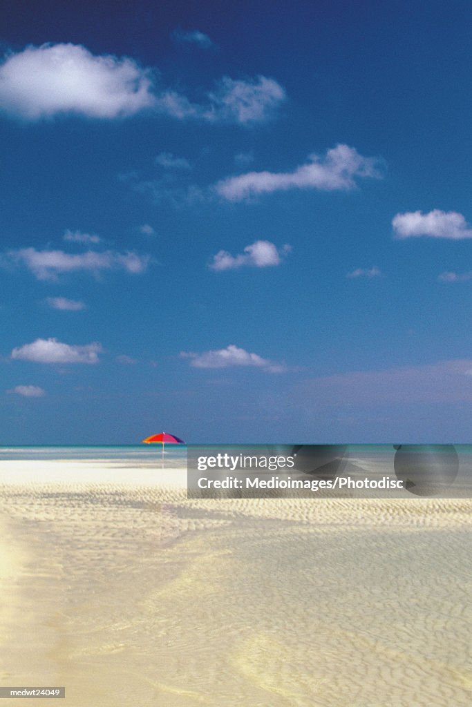 One red umbrella on beach in Lucayan National Park on Grand Bahama Island, Caribbean