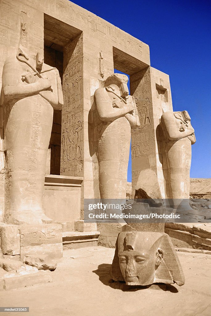 Ramesseum in Luxor: Head of Colossus of Ramesses II Against Osiride Pillars in Second Court, Egypt