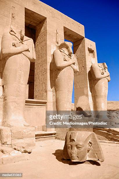 ramesseum in luxor: head of colossus of ramesses ii against osiride pillars in second court, egypt - manlig form bildbanksfoton och bilder