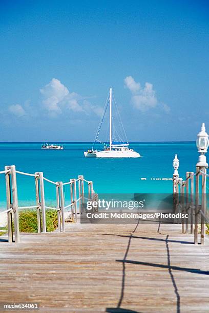 caribbean, turks and caicos islands, providenciales, grace bay beach, boardwalk over a sea - grand bahama stock pictures, royalty-free photos & images