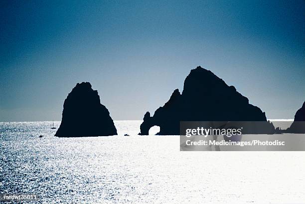 mexico, baja california, cabo san lucas, land's end arch, rock formations in silhouette, sunset - cabo stock pictures, royalty-free photos & images