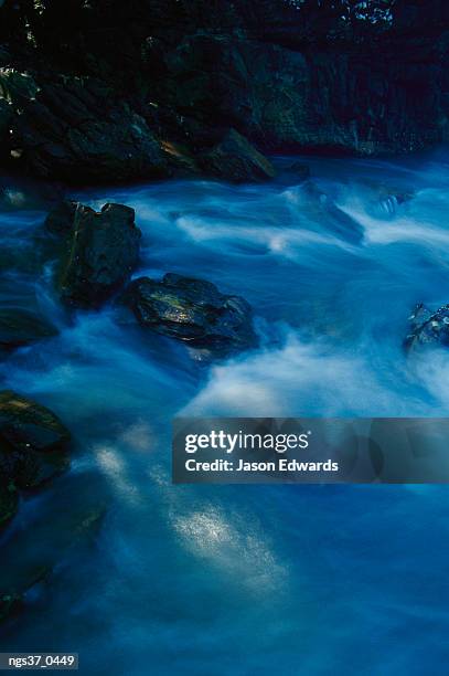 new south wales, australia. blue pastel water breaks over rocks at bittangabee bay. - mitziehen stock-fotos und bilder