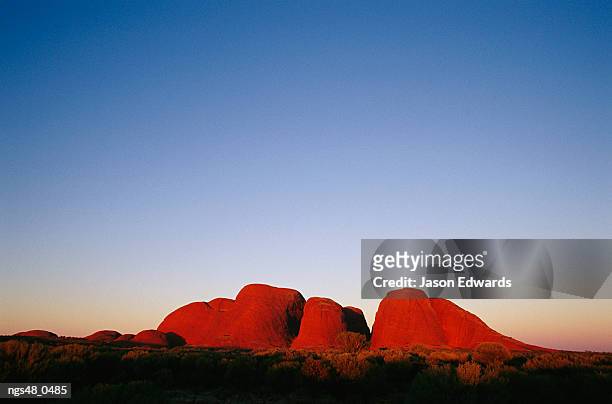 uluru national park, northern territory, australia. twilight view of rock formations. - northern rock stock-fotos und bilder