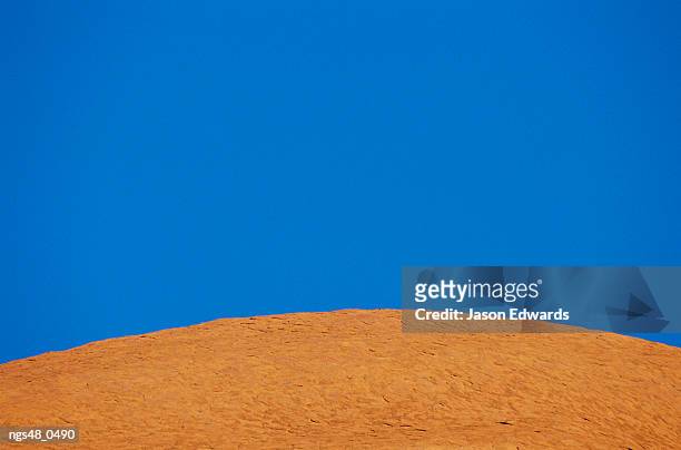 uluru national park, northern territory, australia. abstract of a rock formation under a blue sky. - northern rock stock-fotos und bilder