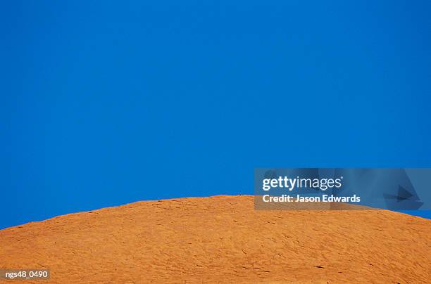 uluru national park, northern territory, australia. abstract of a rock formation under a blue sky. - northern rock stockfoto's en -beelden