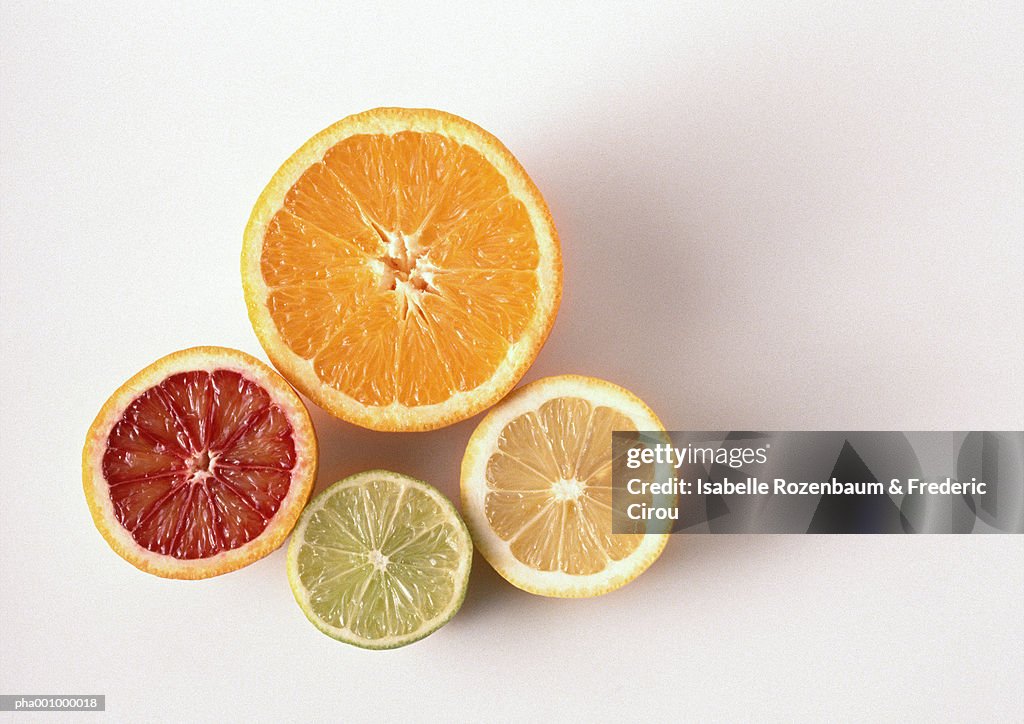 Cross sections of orange, blood orange, lemon, lime, close-up, high angle view, white background