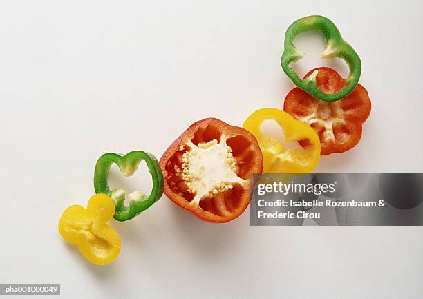 slices of green, yellow and red bell peppers against white background - middelgrote groep dingen stockfoto's en -beelden