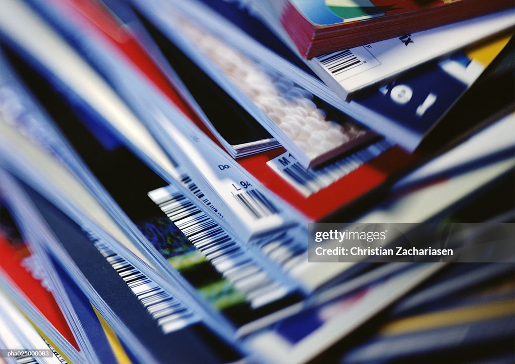 Disorderly stack of magazines, extreme close-up on corners with barcodes, full frame