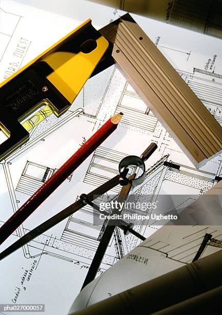 compass, pencil and level on blueprints, close up. - compas à pointes sèches photos et images de collection